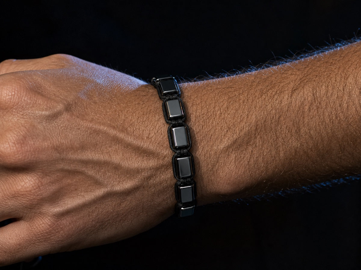 Close-up of a man's wrist wearing a black hematite bracelet