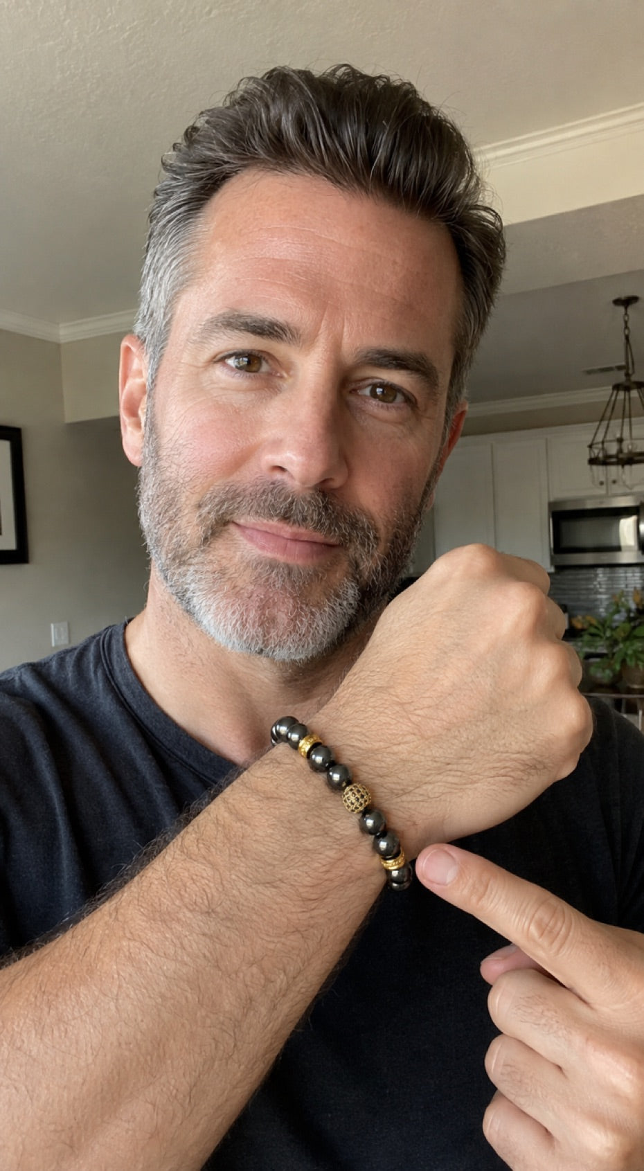 Man adjusting a Zeus Gold hematite bracelet